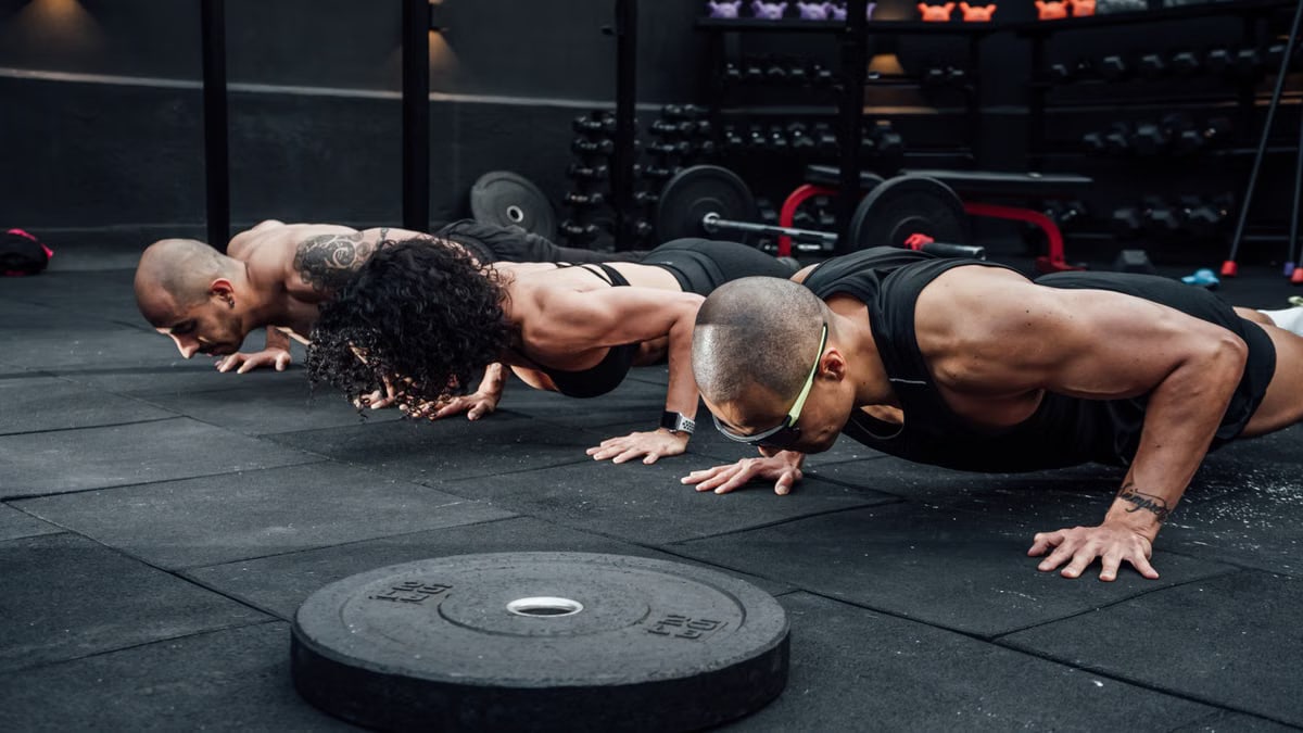 Group workout session in a Mexico City gym with athletes doing push-ups.